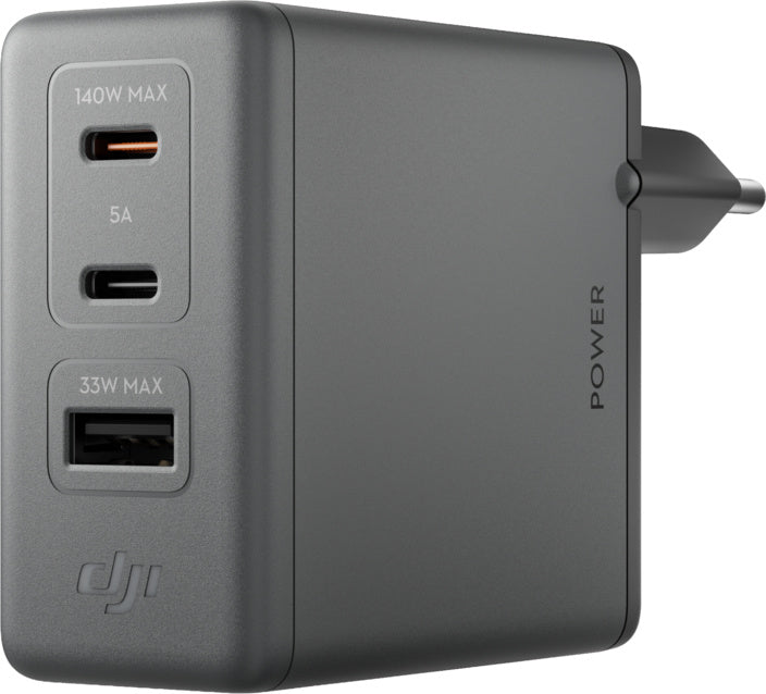 Das DJI Power 140 W GaN Ladegerät (EU) – kompaktes USB-C-Reiseladegerät von DJI ist ein graues Schnellladegerät mit drei Anschlüssen: einem 140-W-USB-C-Anschluss, einem 5-A-USB-C-Anschluss und einem 33-W-USB-A-Anschluss. An der Seite ist das Wort „POWER“ neben einem Steckersymbol abgebildet. Dank PD 3.1-Unterstützung und kompaktem Design ermöglicht dieses Schnellladegerät das effiziente Aufladen all Ihrer Geräte.