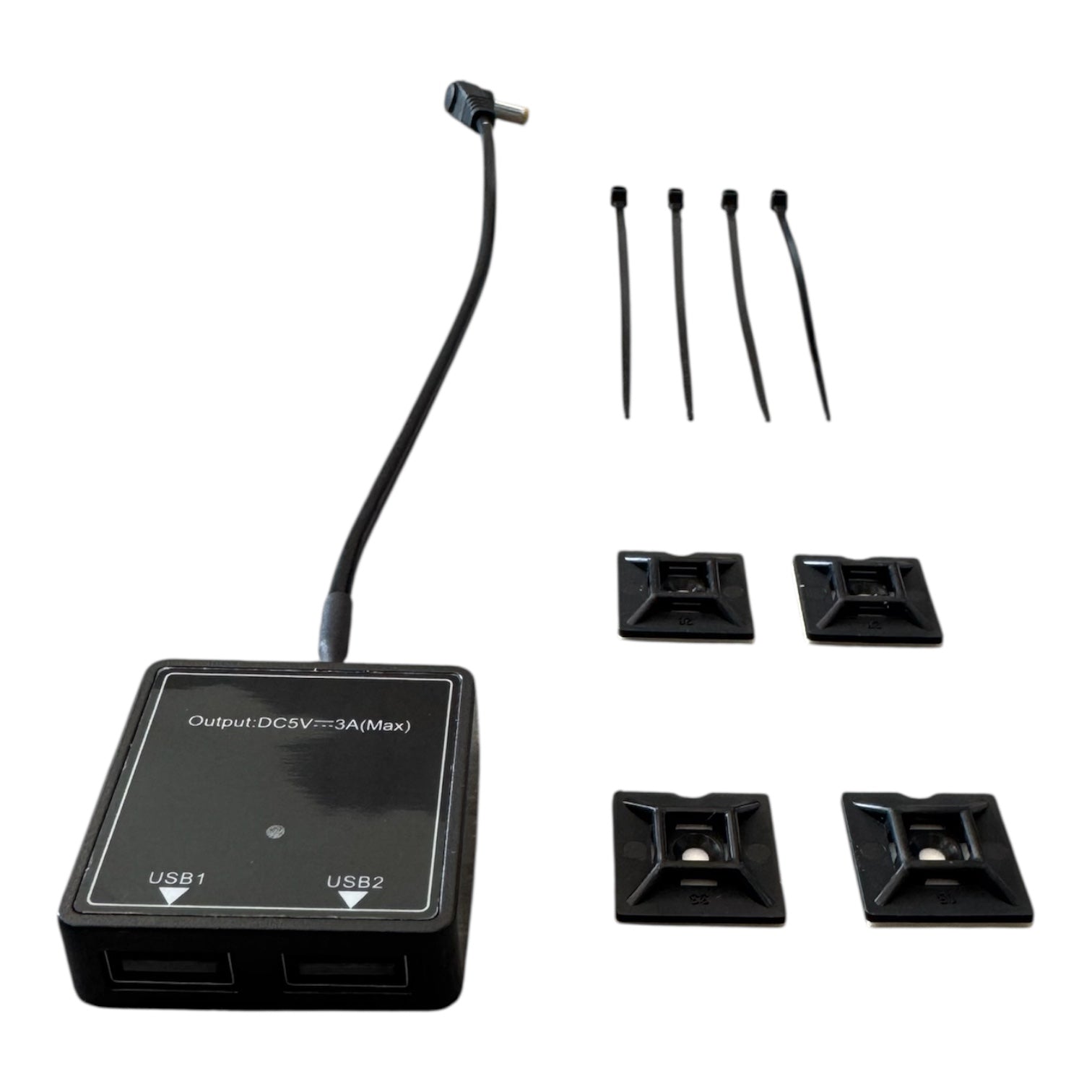 Der CIELOTEC 2-fach USB-A Spannungswandler (5V-3A, 5521 Buchse auf 2x USB-A) in schwarz enthält ein kurzes Kabel, zwei Anschlüsse, vier Kabelbinder und vier selbstklebende Kabelhalterungen, alles sauber auf weißem Hintergrund dargestellt.