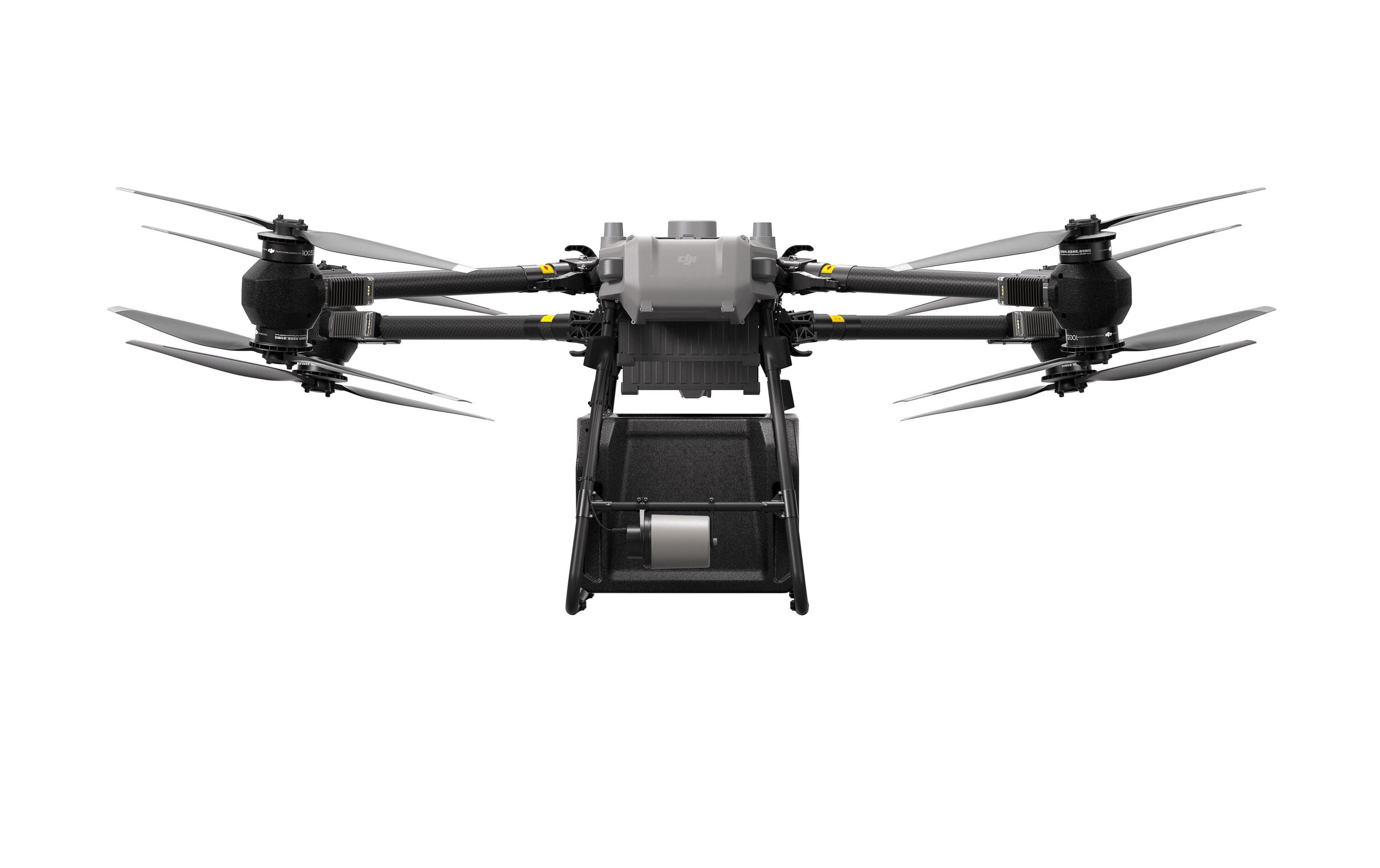 Frontansicht des DJI Delivery Multikopters – FlyCart 30 von DJI Delivery, ein schwarzer Quadrocopter mit ausgefahrenen Propellern, darunter montierter Kamera zur Bildübertragung und sichtbarem Fahrwerk, schwebend bzw. abgebildet vor weißem Hintergrund.