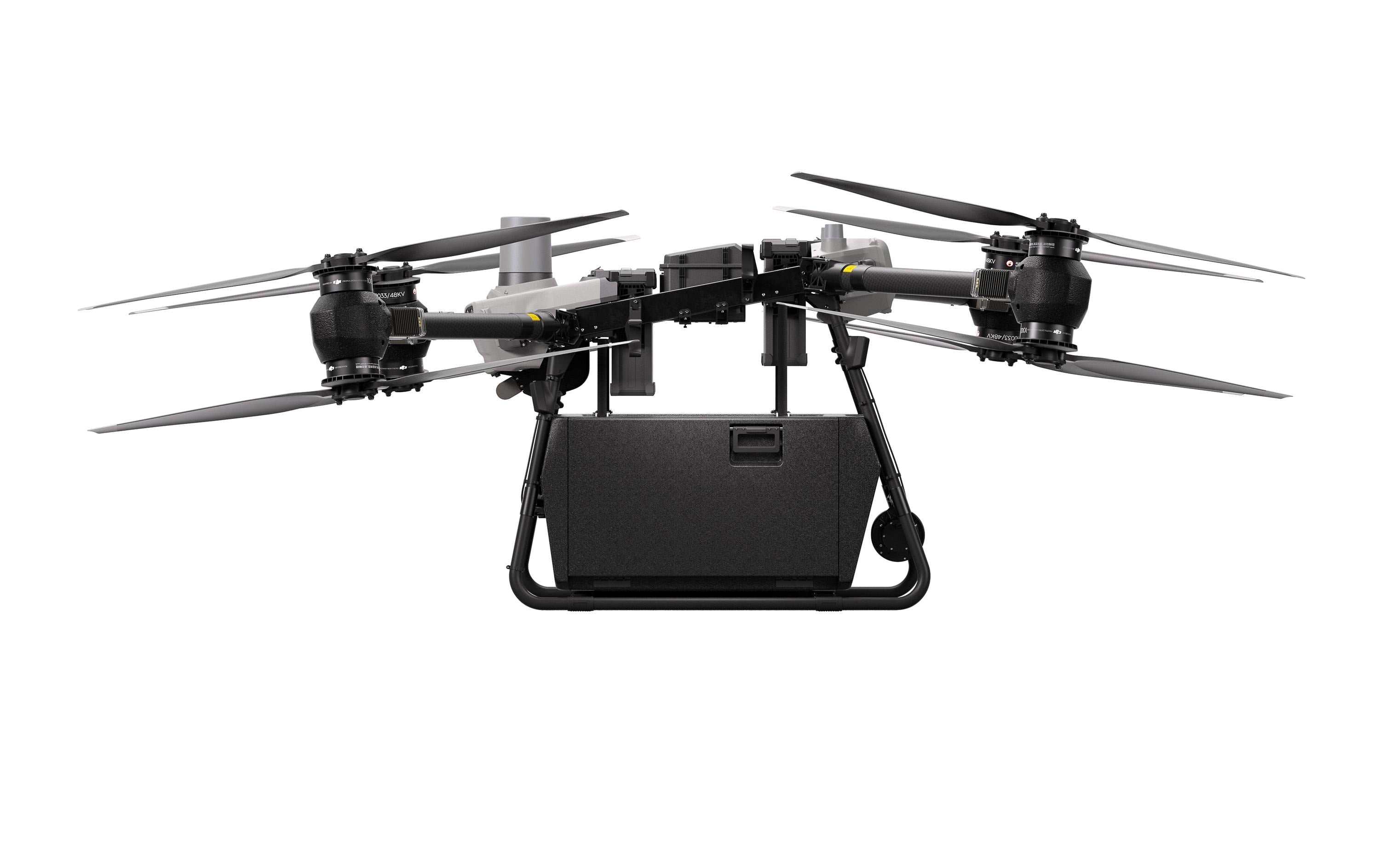Ein DJI Delivery Multikopter – FlyCart 30 von DJI Delivery, mit vier Propellern und einem rechteckigen Mittelkörper in Schwarz, ist von der Seite vor einem weißen Hintergrund abgebildet.