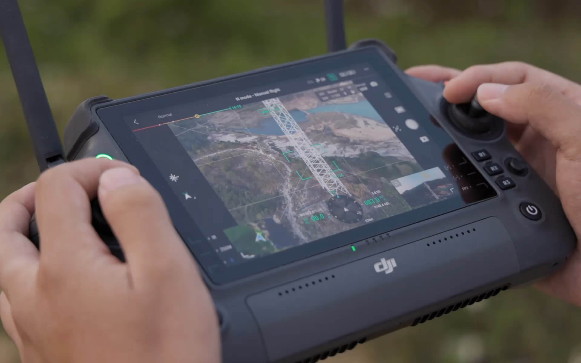 Nahaufnahme von Händen, die eine DJI-Fernbedienung halten, als angehende Pilot:innen mit CIELOTEC Individuelle Einführung (ca. 2h) Drohne steuern; Das Display zeigt eine Live-Karte und Kameraansicht für individuelles Vertiefen von Steuerung und Telemetrie.