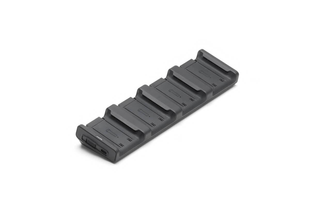 Der DJI Matrice 4 Series Charging Hub von DJI Enterprise ist ein elegantes, graues, rechteckiges Gerät mit sechs Steckplätzen zum gleichzeitigen Laden von M4E- und M4T-Intelligent-Flight-Batterien. Sein minimalistisches Design sorgt für übersichtliches und effizientes Laden.