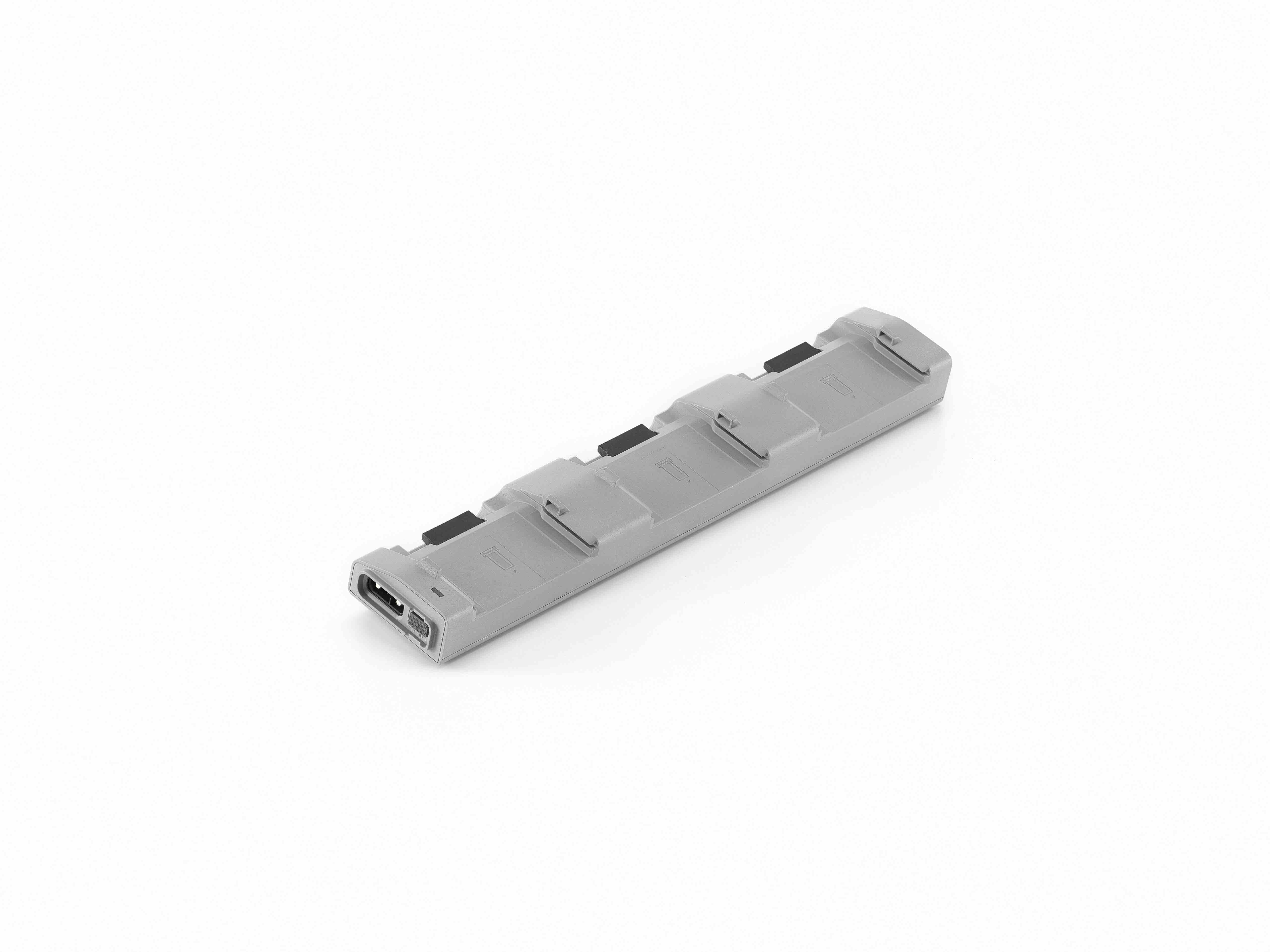 Ein rechteckiger, grauer DJI Ladehub CHX230‑240 von DJI Enterprise, konzipiert für Matrice 4D/4TD TB51 Akkus, mit mehreren Rillen und einem Anschlussport – auf Weiß abgebildet und kompatibel mit intelligentem Akkuladen.