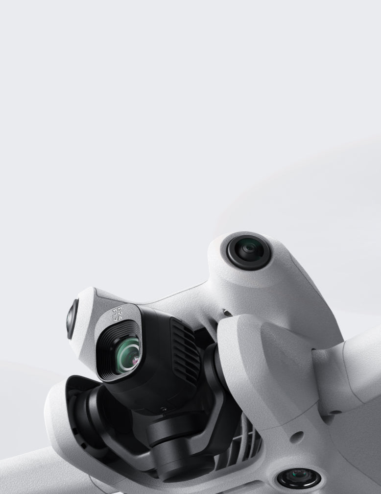 Nahaufnahme einer DJI Mini 4 Pro Fly More Combo (RC 2)-Kamera von DJI Consumer in Weiß mit mehreren Objektiven auf hellgrauem Hintergrund. Die schlanken Kurven und das ausgeklügelte Gimbal-System der Drohne deuten auf eine fortschrittliche Bildgebungsleistung hin.