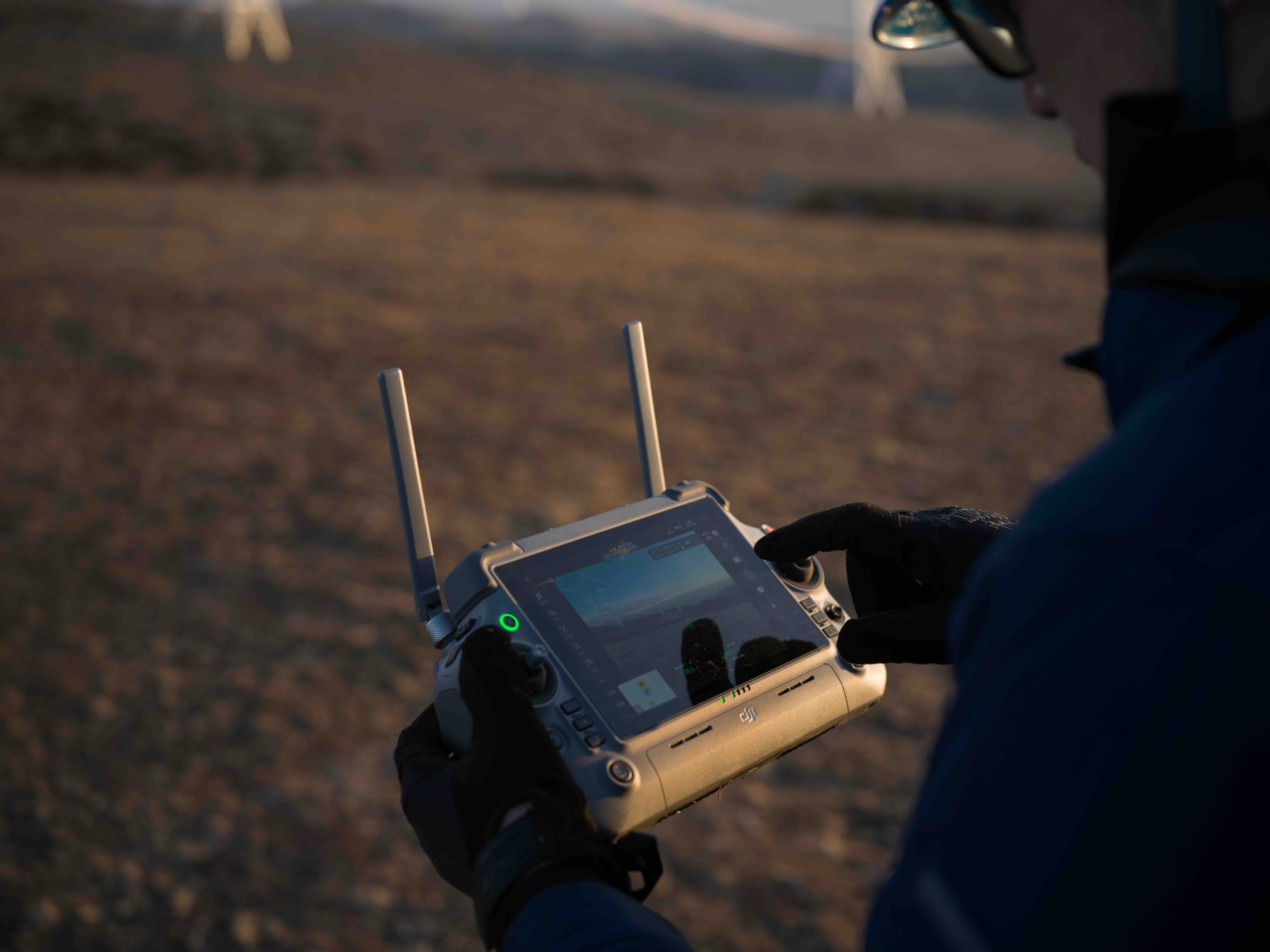 Eine Person mit Handschuhen steuert im Freien die DJI Matrice 4D Standalone Combo – die präzise, wetterfeste Vermessungsdrohne von DJI Enterprise (IP55, inkl. Care Enterprise Plus) – ideal für Vermessung oder automatisierte Inspektionen.