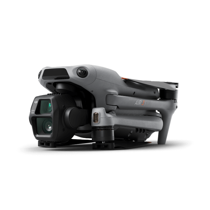 Eine kompakte DJI Air 3S Fly More Combo (RC 2) Drohne im grauen Design mit 1-Zoll-CMOS-Sensor steht gefaltet vor schwarzem Hintergrund. Sie verfügt über eine Frontkamera, sichtbare Sensoren und den Modellnamen an der Seite.
