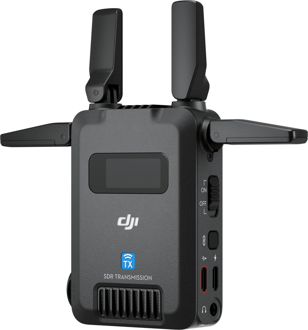 Der DJI Pro Digitale Bildübertragung TX – DJI SDR Transmission Transmitter TX verfügt über zwei Antennen, ein Display, Steuertasten und Anschlüsse. Auf der Vorderseite sind DJI-, TX- und SDR-Übertragungsetiketten für zuverlässige WLAN-Übertragung und 1080p FHD-Qualität angebracht.