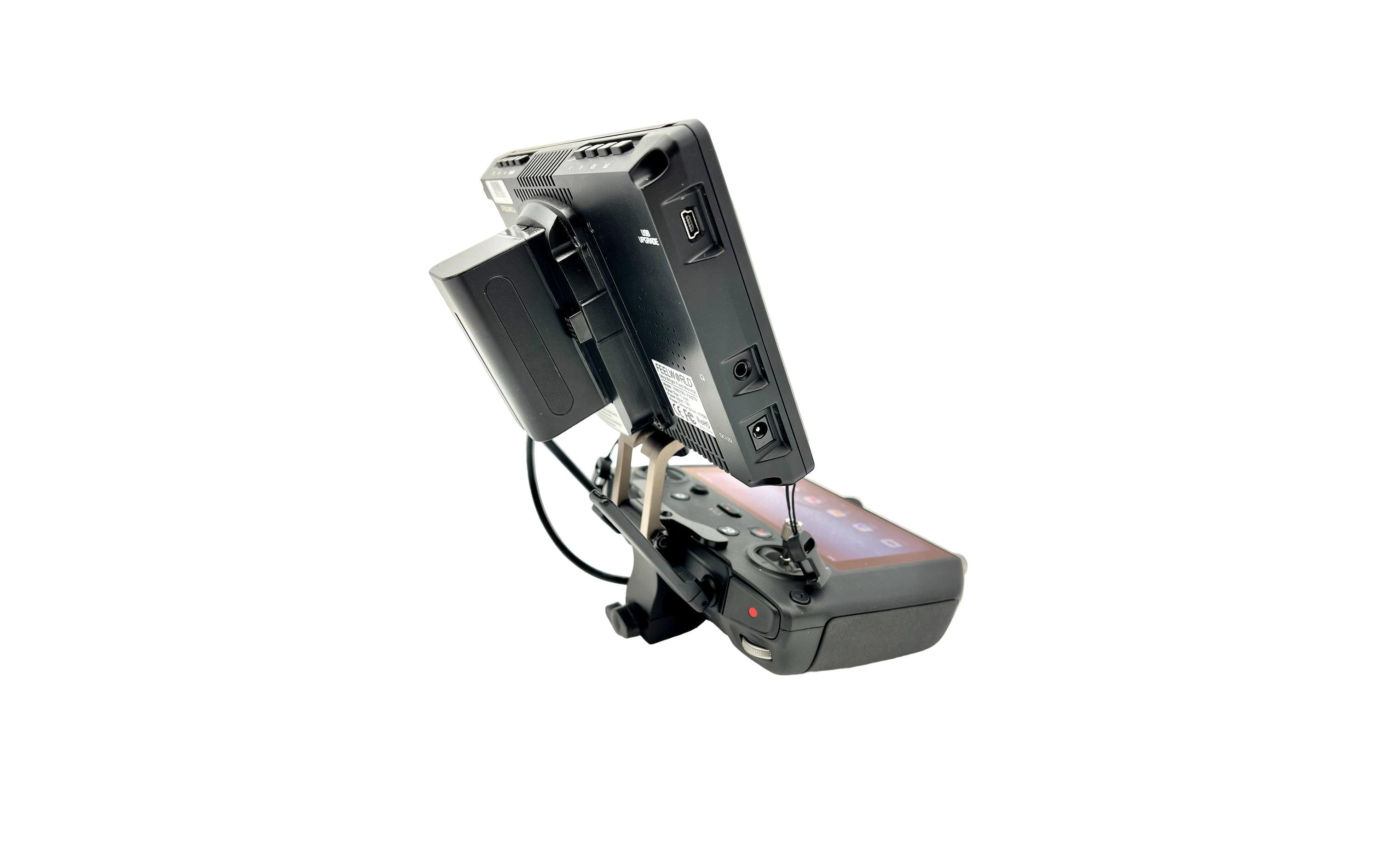 Ein schwarzes elektronisches Gerät, ähnlich dem LifThor Monitor & Stativ Halterung II für DJI RC Pro von Lifthor, ist mit mehreren Anschlüssen und Kabeln fest montiert. Eine externe Monitorhalterung wertet dieses Kamera- oder Überwachungssystem vor weißem Hintergrund auf.