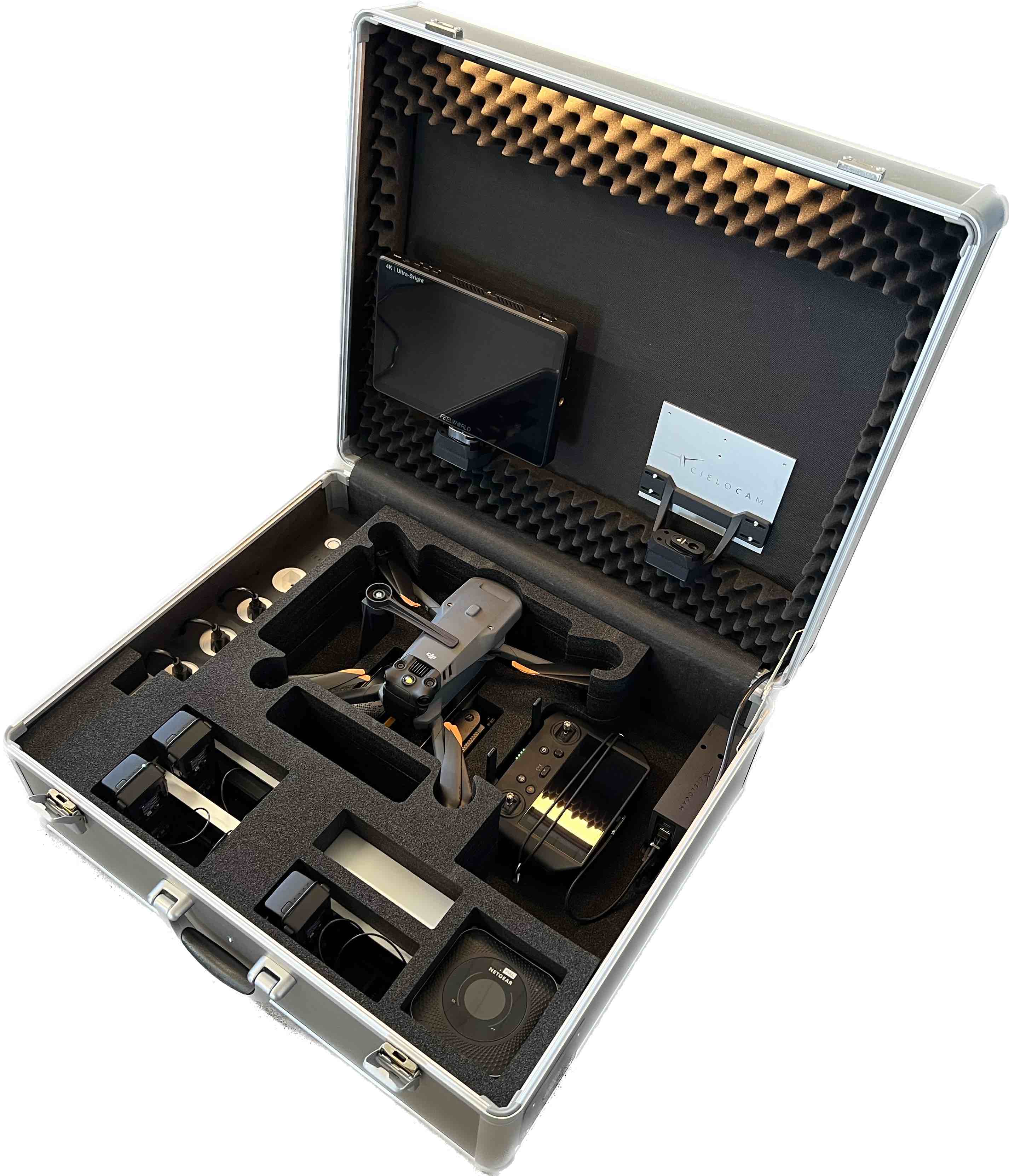 In einem offenen, mit Schaumstoffeinlagen ausgestatteten M3 EASYCHARGE-Koffer von CIELOTEC finden eine Kompaktdrohne, ein Smart Controller, verschiedene Objektive, ein Monitor und Mavic 3 Flugakkus der DJI M3-Serie Platz – alles übersichtlich und sicher verstaut.