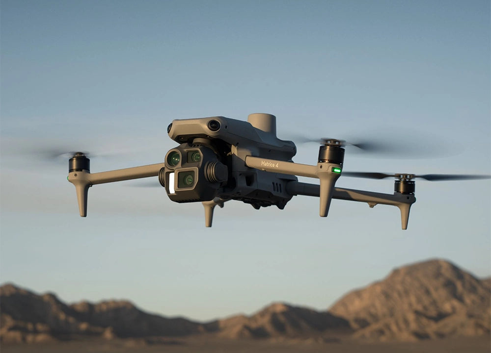 Ein DJI Enterprise Multikopter Matrice 4 Enterprise (M4E) fliegt über die bergige Wüste und erfasst Details präzise. Seine Rotorblätter schneiden durch den Himmel, während er intelligente Operationen durchführt und mühelos durch das felsige Gelände navigiert.