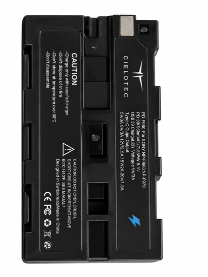 Ein rechteckiger schwarzer CIELOTEC NPF 980 Lithium-Ionen-Akku (9.800 mAh Monitor-Akku) mit integrierter Ladeelektronik, PD-30W-Schnellladefunktion, USB-C- und USB-A-Anschlüssen, Kompatibilität mit Sony NP-F, Warnhinweisen und Zertifizierungsaufklebern, einem silbernen Anschluss sowie einem blauen Blitzsymbol auf der Oberfläche.